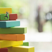 Little climbers move up a "stack" of coloured blocks. Pic by SHutterstock
