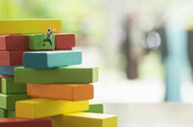 Little climbers move up a "stack" of coloured blocks. Pic by SHutterstock