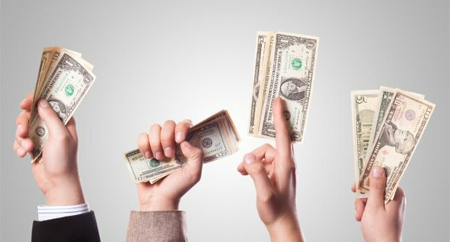 hands waving dollar bills in the air