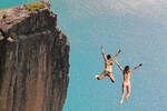 People diving off a cliff