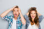 Shocked couple scream and clutch their hair