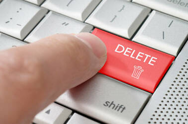 A finger pressing a delete key