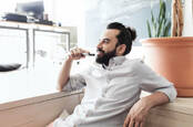 Man with bun sucks on vape. Photo by shutterstock