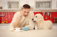 Man and dog eat dog food. pic by shutterstock