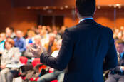 man gives lecture faces crowd