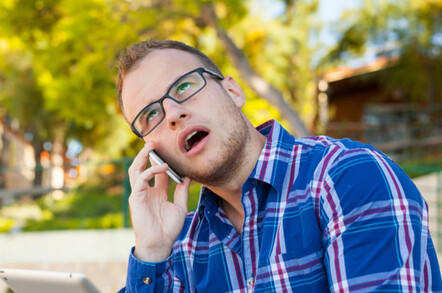 man rolls his eyes on mobile phone