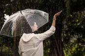 rainy day - woman with umbrella checks to see it is still raining