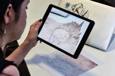 Layla Gordon pointing tablet at 2D map of Mars to generate 3D image