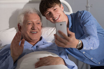 Teen takes selfie with patient in hospital bed (in homey setting)