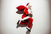 Man dressed as Santa claus runs away with loot in a bag.