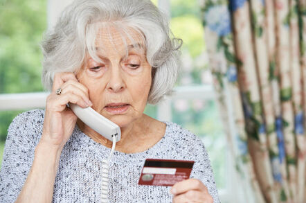 Older woman on phone gives credit card number.