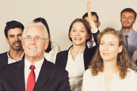 Businesswoman enthusiastically volunteers, raises hand