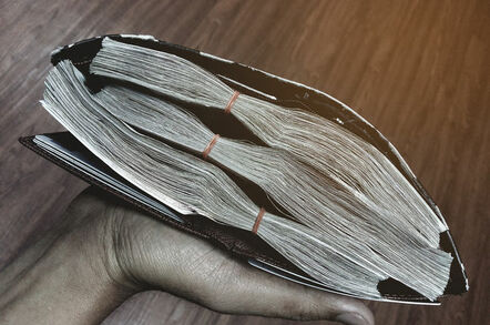 Wallet stuffed full of bundles of cash