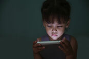 child watches tablet in the dark