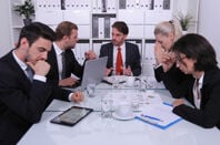 Office workers in meeting seem frustrated.
