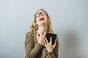 Woman wails in despair while clutching a tablet.