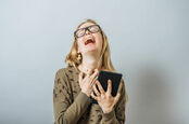 Woman wails in despair while clutching a tablet.