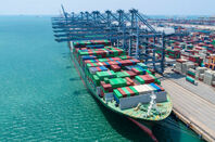 Container ship docked at port with crystal blue waters. 
