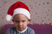A sad child in a holiday hat