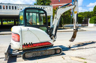 Mini excavator with narrow bucket for laying fiber-optic cable line