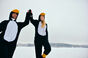 Couple dressed as penguins celebrate in the snow