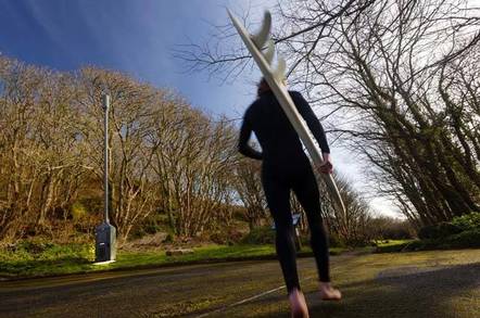 Cornwall: A barefoot surfer in a wetsuit walks past a clump of bushes with a 8-metre high "telescopic" 4G mast in the middle.