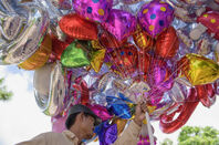helium balloons - massive bunch held by man selling them