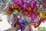 helium balloons - massive bunch held by man selling them