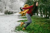Woman leaping from winter to spring