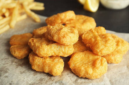 Chicken nuggets on paper with side of fries