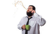 A man spits out his coffee