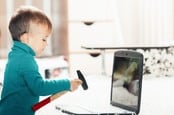 Boy fixing computer with hammer