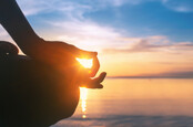 Person meditating on beach