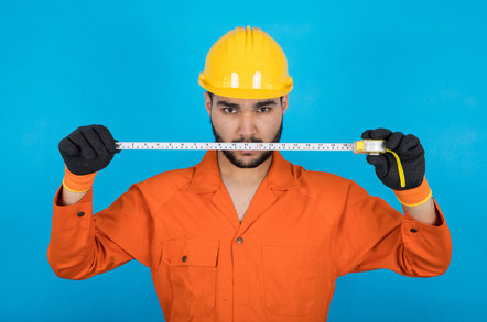 Repairman in orange overalls threateningly wields tape measure