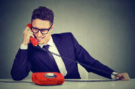 Pushy young salesman business man advertising his best product on a phone