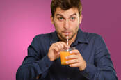 Man drinks juice through straw