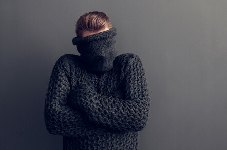 Young man covers face with jumper