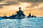 Military navy ships in a sea bay at sunset time