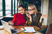 Sceptical looking people check something on a laptop