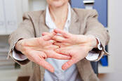 A woman stretches her hands in preparation to write