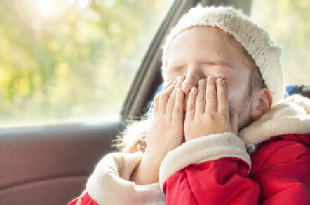 Young girl feeling bored in passenger seat of car