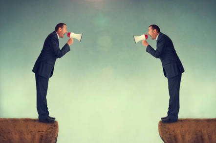 Two businessmen facing each other shouting into loudhailers