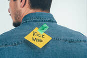 kick me sign on man's back