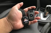 Man holds the BMW f30 key fob with an apple watch showing the connected drive information.