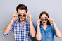 Couple wearing sunglasses looking surprised by something