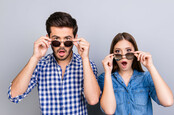 Couple wearing sunglasses looking surprised by something