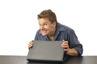 Man with guilty grin carefully closes laptop