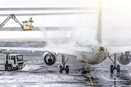 Ground crew de-icing aircraft
