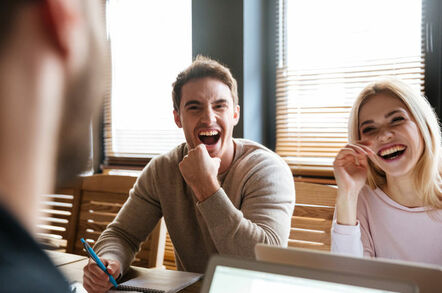 laughing colleagues in front of laptops