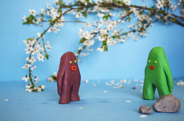 Two plasticine blobs against a garden landscape